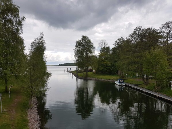 En rolig flod med en bro og træer på begge sider.