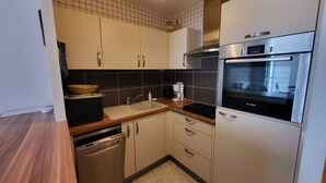 A modern kitchen with stainless steel appliances, a dishwasher, and a sink.