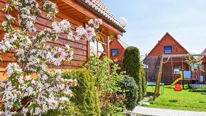 A wooden house with a garden, a play area, and a clear sky. - Awesome home in Bobolin with kitchen (Bobolin)
