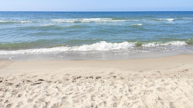 A beach with waves approaching the shore, sandy beach, and clear sky. - Awesome home in Bobolin with kitchen (Bobolin)