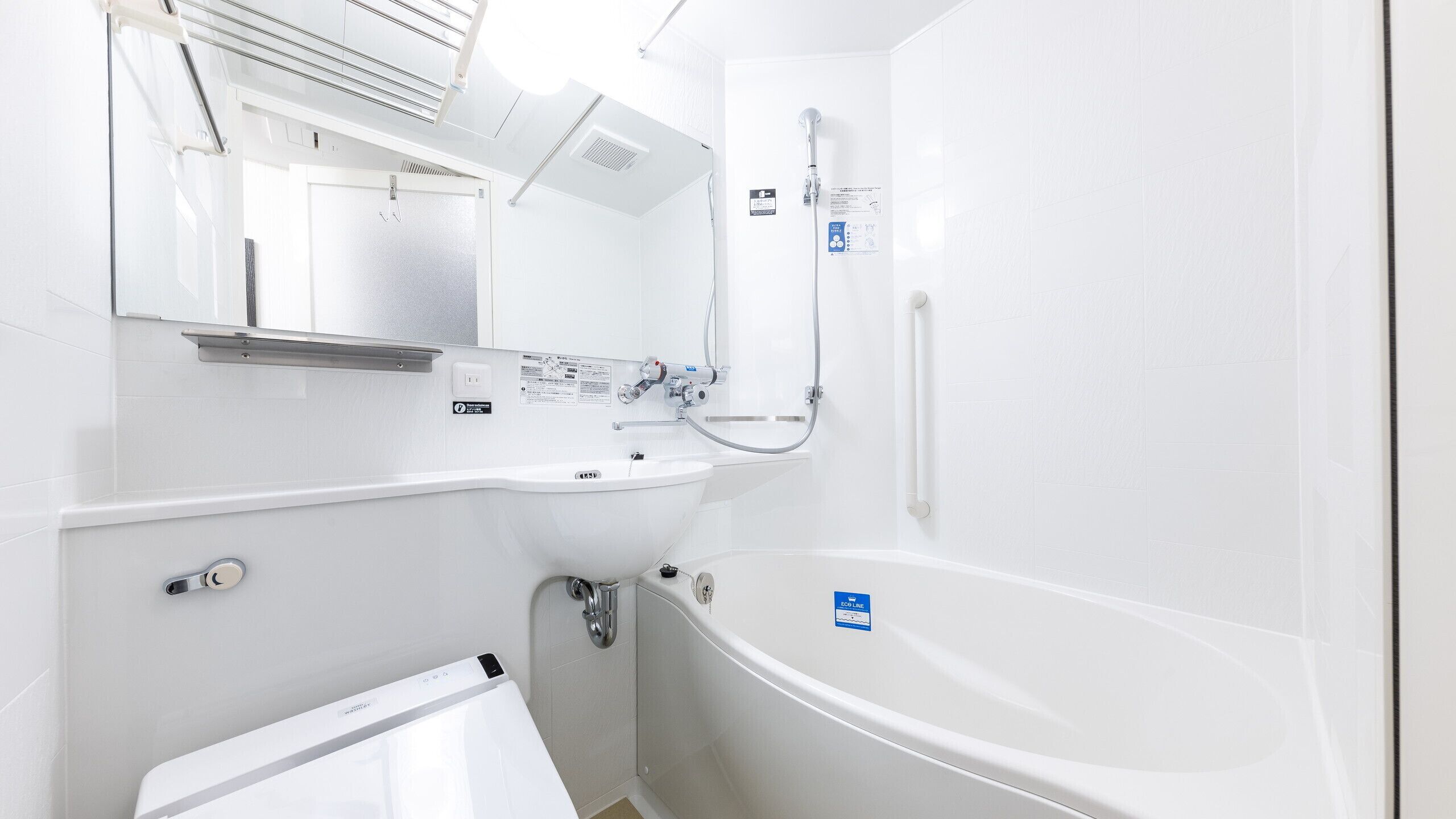 Une salle de bain moderne avec un lavabo blanc, un miroir et une baignoire.