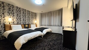 Een hotelkamer met twee bedden, een grote spiegel, een flatscreen televisie en een raam met gordijnen.