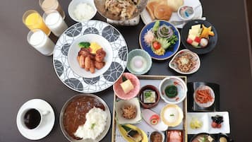 A variety of dishes and beverages on a table, including rice, meat, vegetables, and a cup of coffee.