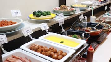 A buffet with various dishes including meats, vegetables, and sauces.