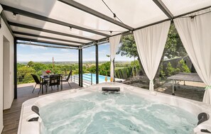 A hot tub with a view of a swimming pool and landscape. - Awesome home in Beretinec with sauna (Beretinec)