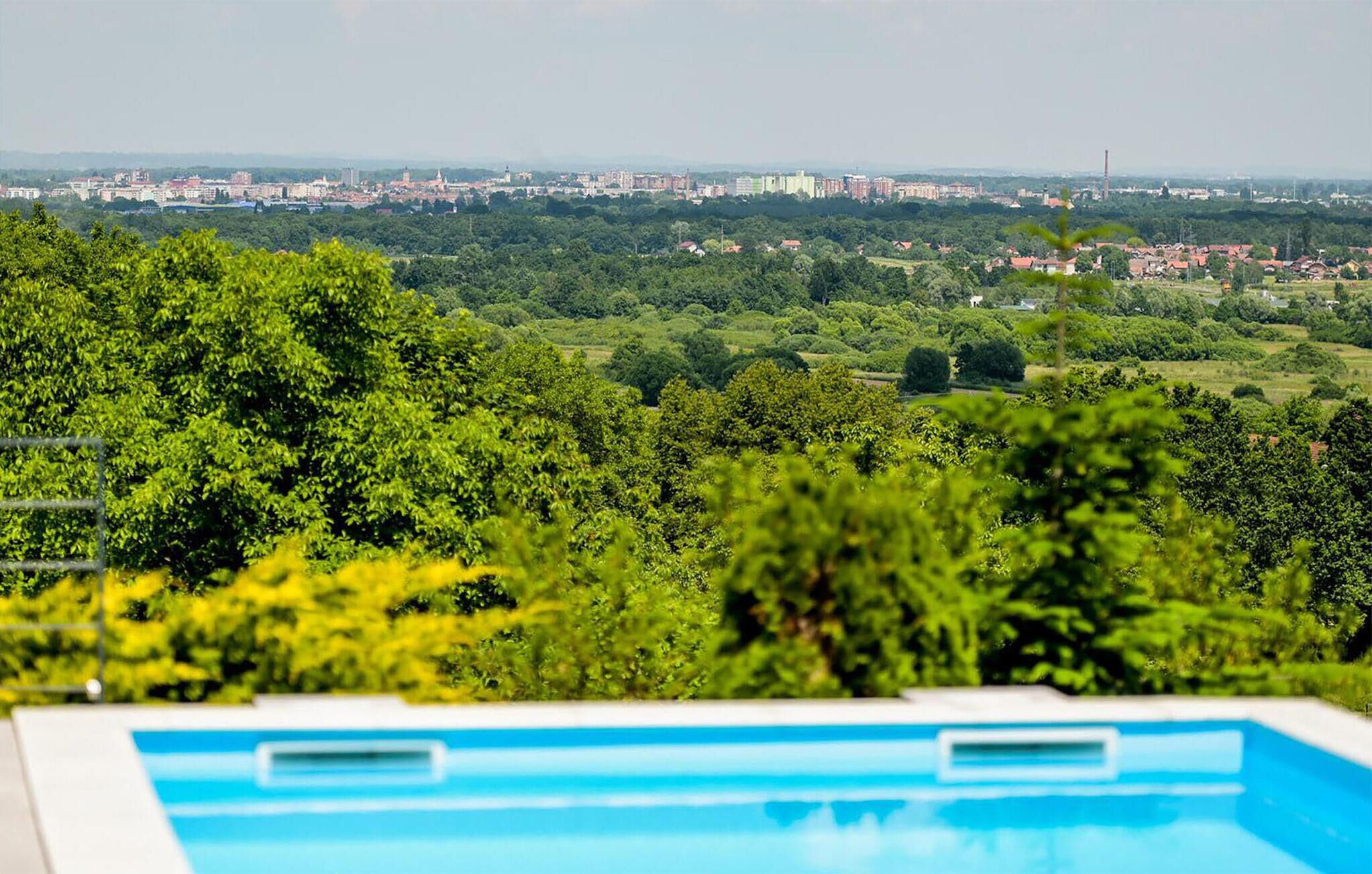 Una piscina con vistas a un paisaje urbano al fondo.