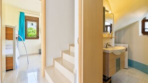 A modern bathroom with a sink, mirror, and a washing machine. - Smaragdi BeachFront Villa (Asklipeio)