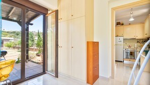 A modern kitchen with a refrigerator, oven, and wooden cabinets. - Smaragdi BeachFront Villa (Asklipeio)