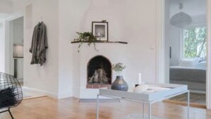 Un salon moderne avec une cheminée, une plante suspendue et une table à manger.