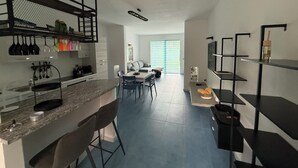 Een moderne keuken met een eethoek, een inbouwboekenplank en een groot raam.