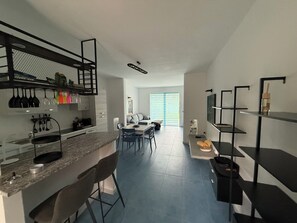 Een moderne keuken met een eethoek, een inbouwboekenplank en een groot raam.