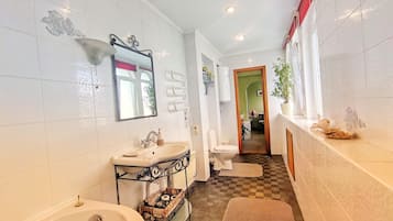Bañera con ducha, secador de pelo, toallas, papel higiénico