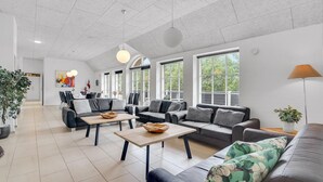 Una sala de estar moderna con un conjunto de sofá, una mesa de centro y un comedor con sillas.