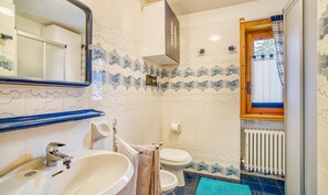 Bathroom features a sink, mirror, toilet, and decorative tile pattern.