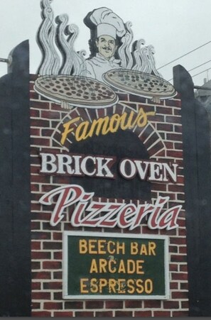 A brick oven pizza restaurant sign with a chef illustration and mentions a beech bar, arcade, and espresso. - Beech Mountain Retreat With Mountain View<br> (Beech Mountain)