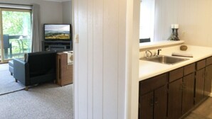 Eine moderne Küche mit integriertem Spülbecken und einer Essecke mit Sofa und Fernseher.