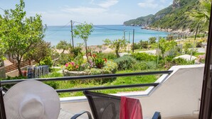 Ein Balkon mit Meerblick, ein Stuhl und ein Hut.