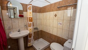 Ein Badezimmer mit Waschbecken, Toilette, Dusche und Spiegel.