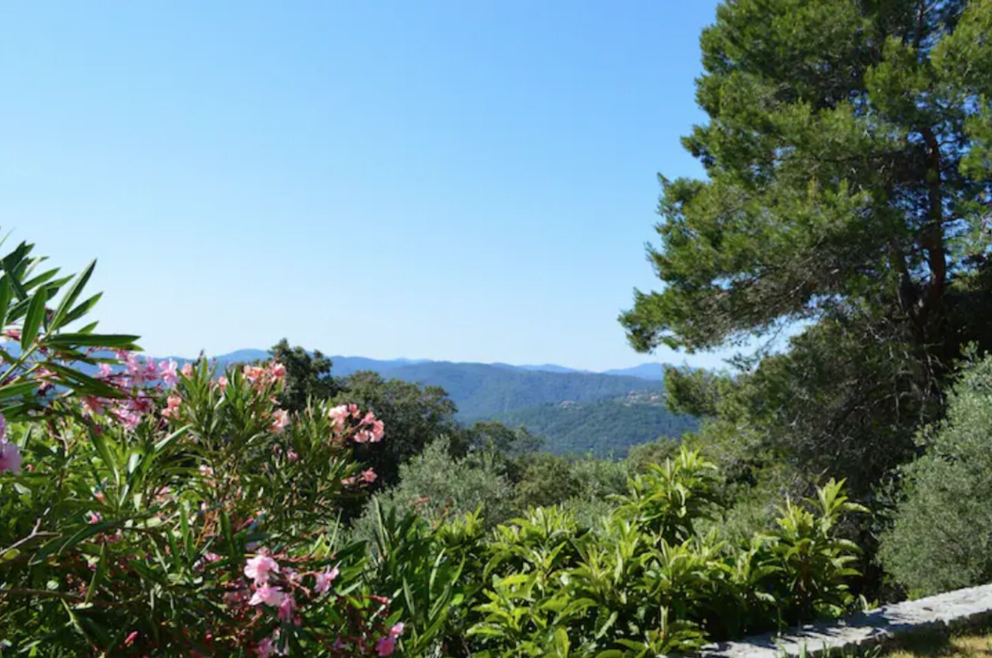 A mountainous landscape with dense greenery and a clear sky.