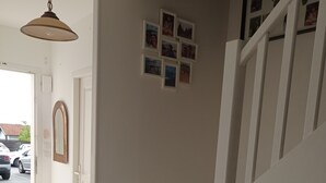 A staircase with a white handrail leading to an upper floor. There is a small rug at the bottom of the stairs and a door to the left. - Maison Mitoyenne Avec Ascenseur (Boucau)