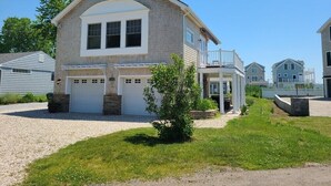 A two-story house with a garage, a covered porch, and a well-maintained lawn. - Beach House steps to private beaches in sought after location! (Old Saybrook)