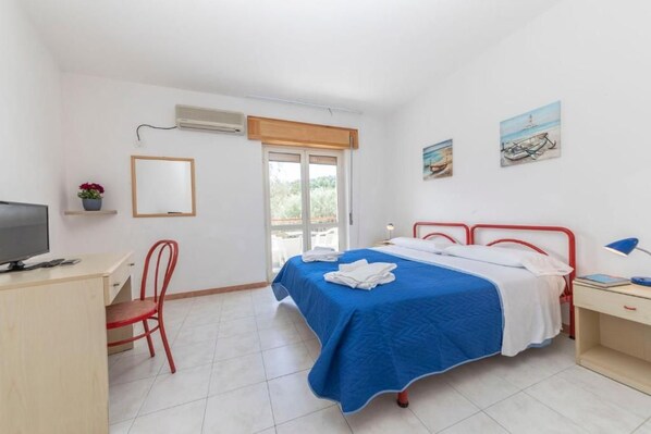 A bedroom with a bed, a desk, a chair, a television, and artwork on the wall. - li Cylentos (Santa Marina)