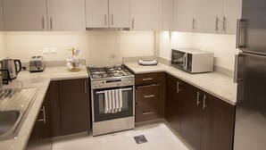 Een moderne keuken met roestvrijstalen apparatuur, houten kastjes en een granieten aanrecht.