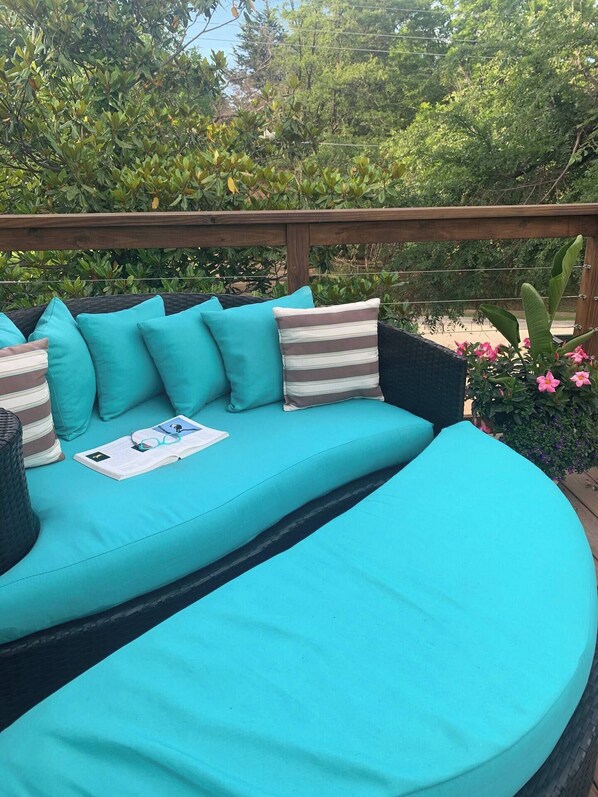 A turquoise outdoor seating area with cushions and a book.