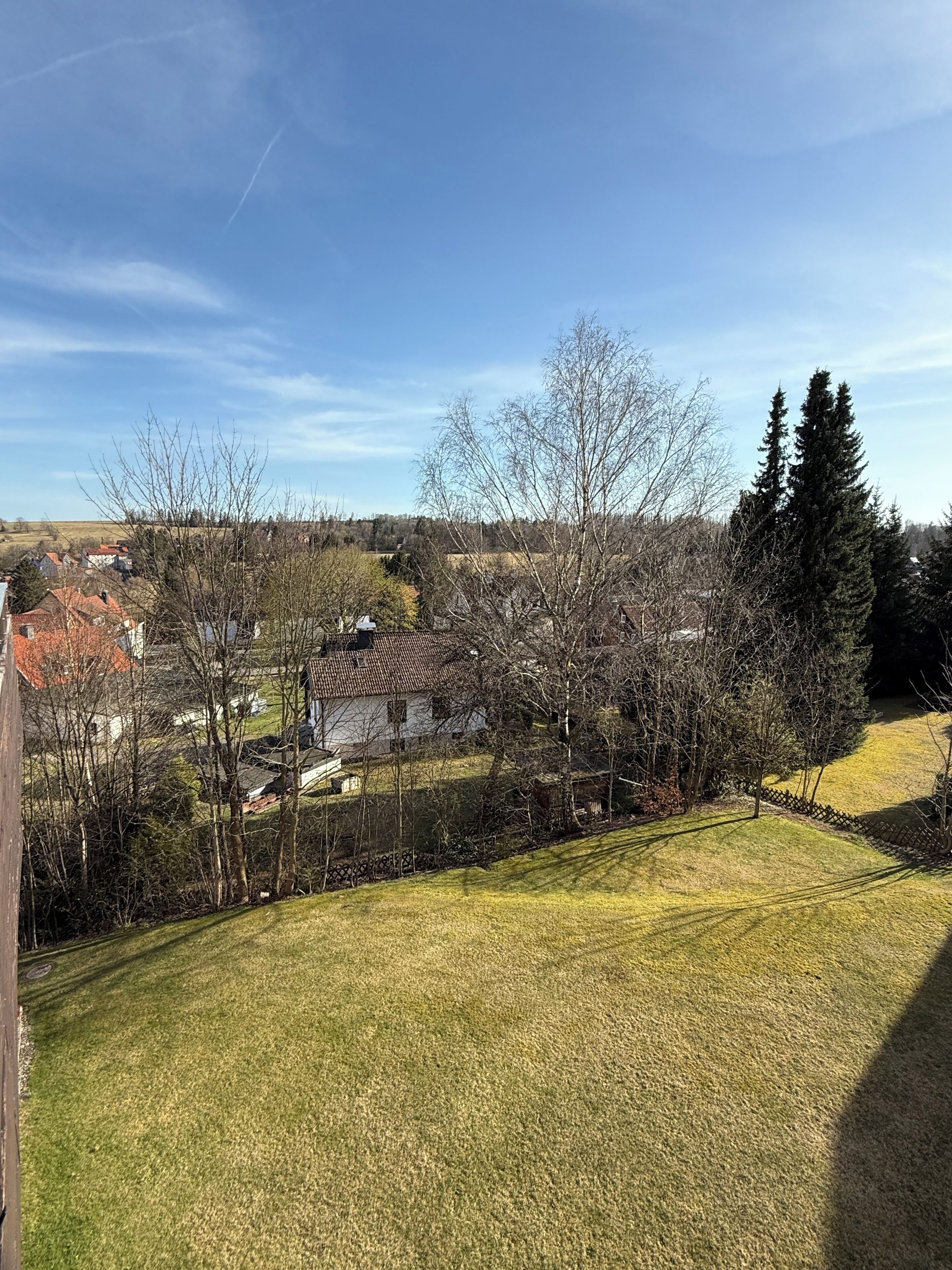 Zona residencial con casas, patio cercado y cielo despejado.