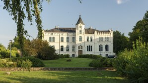 Un edificio grande e histórico con una torre destacada y una fachada simétrica.