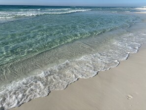 Een strand met helder water en rustige golven.
