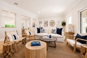 A modern living room with a sofa, chairs, a coffee table, and a lamp.