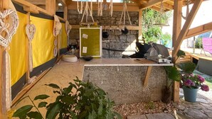A rustic wooden structure with a stone wall, a yellow wall with decorative items, and a hanging dreamcatcher. - Apartment in Funtana with Terrace, Air condition, WIFI, Washing machine (4982-7) (Funtana)