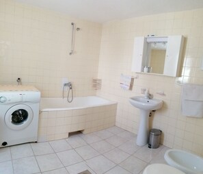 Banheira, secador de cabelo, toalhas de banho