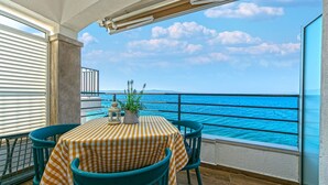 A balcony with a checkered tablecloth, two chairs, a potted plant, and a lantern. - Apartment in Drašnice with Seaview, Terrace, Air condition, WIFI (4992-1) (Drašnice)