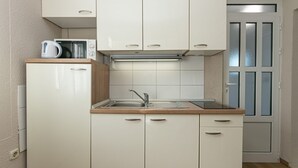 A compact kitchen with white cabinets, a stainless steel sink, and a microwave. - Apartment in Drašnice with Seaview, Terrace, Air condition, WIFI (4992-1) (Drašnice)