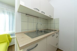 Køleskab, mikrobølgeovn, kogeplade, køkkentøj/tallerkener/redskaber