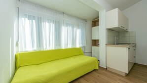 A small, bright room with a sofa, a kitchenette, and a window with sheer curtains. - Apartment in Drašnice with Seaview, Terrace, Air condition, WIFI (4992-3) (Drašnice)