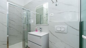 A modern bathroom with a glass shower enclosure, a white vanity with a mirror, and marble walls. - Apartment in Drašnice with Seaview, Terrace, Air condition, WIFI (4992-3) (Drašnice)