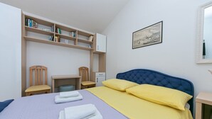A bedroom with a bed, two chairs, a desk, a bookshelf, and a framed picture on the wall. - Apartment in Drašnice with Seaview, Terrace, Air condition, WIFI (4992-3) (Drašnice)