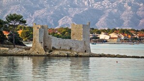 A historical stone castle by a calm body of water with mountains in the background. - Apartment in Vir with Seaview, Balcony, Air condition, WIFI (3777-1) (Vir)