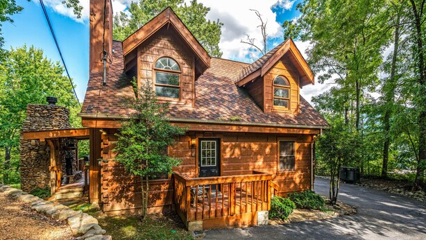 A rustic log cabin with a stone foundation, a chimney, and a porch. - Dog Friendly, Mtn Views, Wood Fireplaces, Hot Tub, Pool Table, Pools, Pickleball (Gatlinburg)