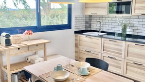 Una cucina moderna con una grande finestra, mobili in legno, un piano di lavoro nero e lampade a sospensione.