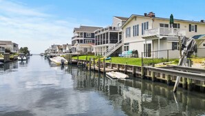 A canal with houses on either side and boats docked. - Waterfront 5BR • Dock • BYO Boat • Sleeps 16 • 2 Living Rooms • 2 Miles to Beach (Selbyville)