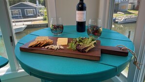 A table with a bottle of wine, two glasses, a cheese board, and crackers. - Waterfront 5BR • Dock • BYO Boat • Sleeps 16 • 2 Living Rooms • 2 Miles to Beach (Selbyville)