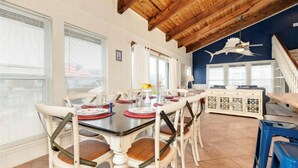 A dining area with a wooden ceiling, white walls, and a view of the outside. - Oceanview Beach House - steps from the beach, really close to Galveston. TipSea! (Galveston)