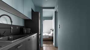 Una cocina moderna con estufa integrada, un lavamanos y un refrigerador compacto.