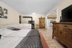 A bedroom with a bed, a television, a cabinet, and a kitchen in the background. - Pretty villa with above ground pool, magnificent sea views (Plomin - Zagorje)