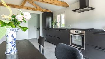 Eine moderne Küche mit dunklen Schränken, einem eingebauten Backofen und einem Fenster mit Blick.