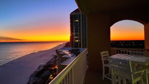 Ein Balkon mit Blick auf den Strand bei Sonnenuntergang.